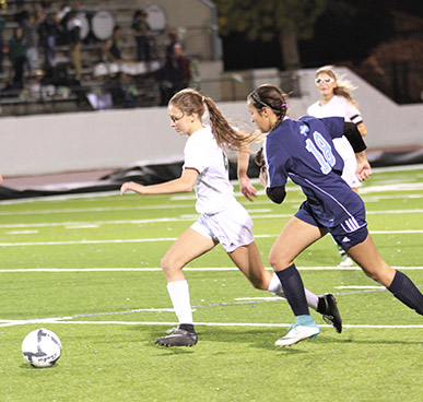 Memorial Stadium Soccer Field - 2 girls running after a soccer ball on a soccer field.