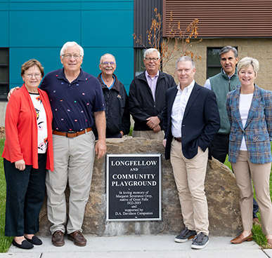 Longfellow Community Playground- Group of people standing together in front of a sign "Longfellow Community Playground"