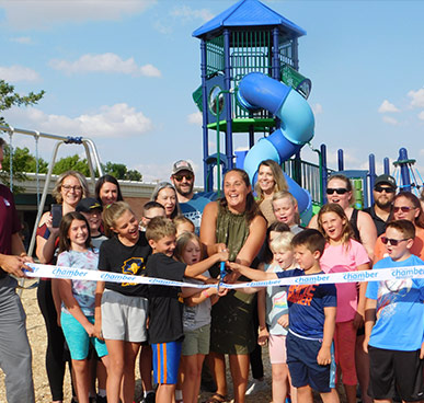 Group of people doing a ribbon cutting at the new riverview elementary playground