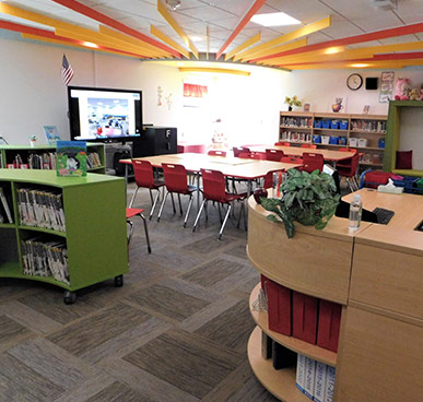 Whittier Elementary Library - A Room with book cases, chairs, desk, and television